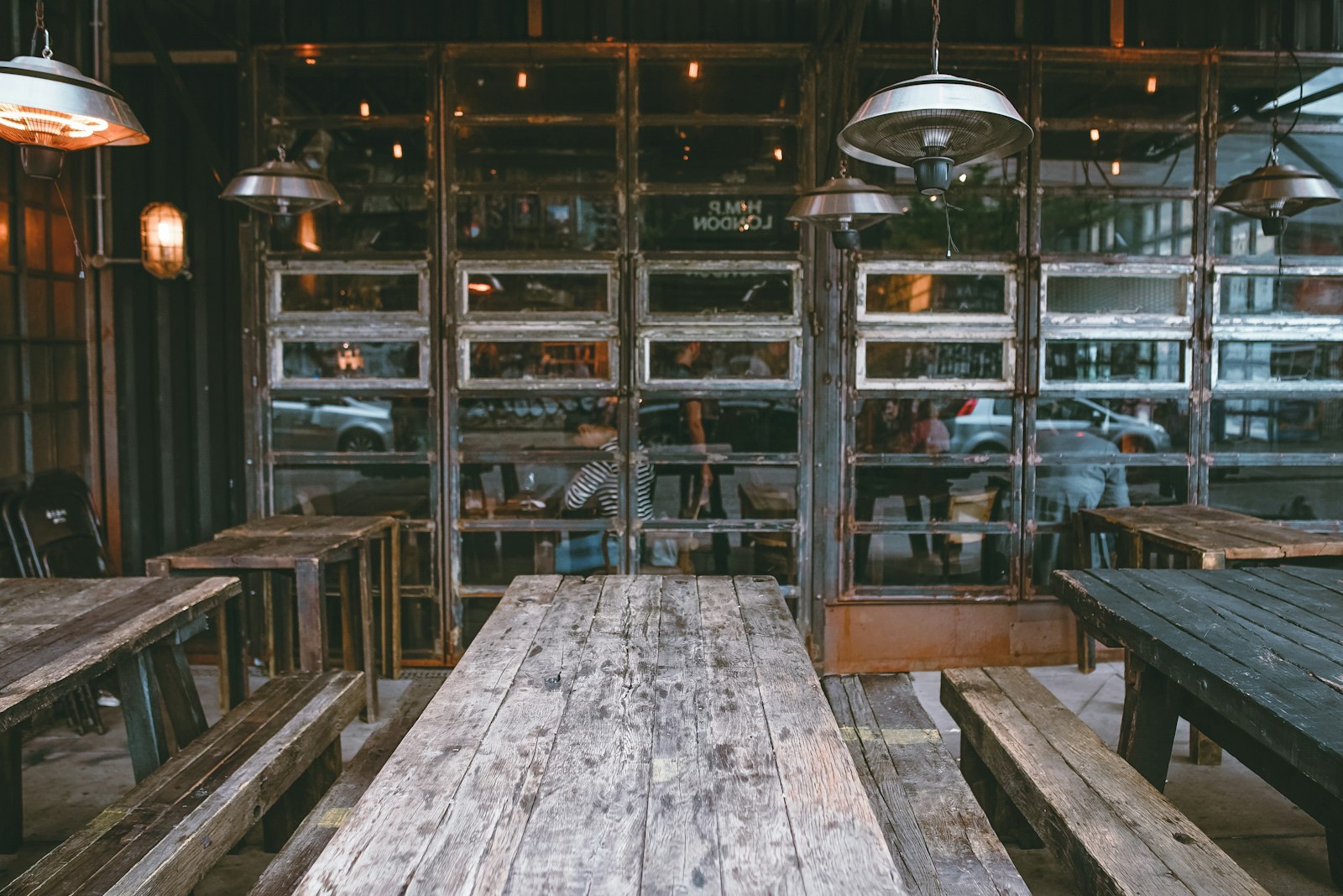 Espace de restaurant avec banquettes en bois, verrière et lumière du jour